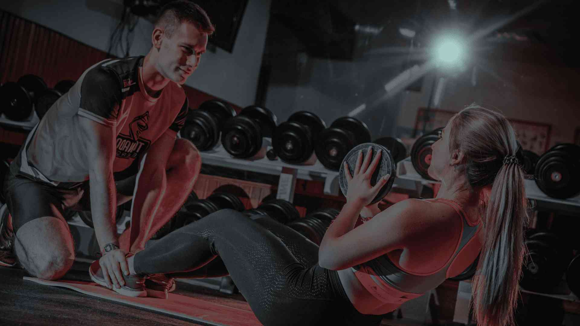 Un hombre y una mujer haciendo ejercicio en un gimnasio.